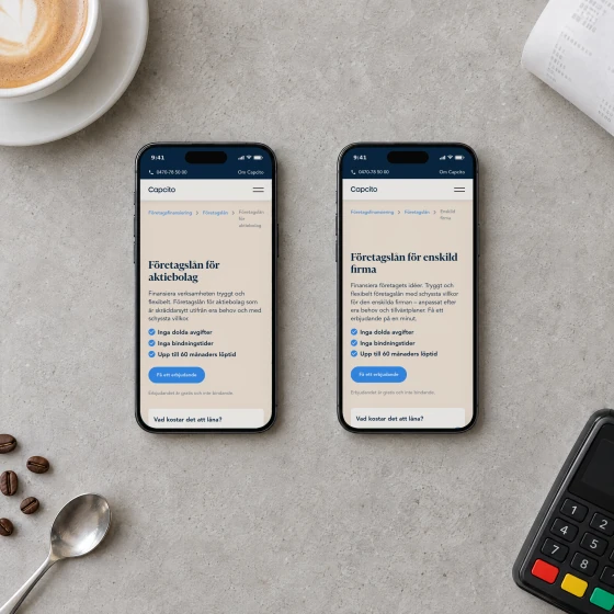 Two phones on a concrete café counter, showing Capcito's pages for business loans for limited companies and for sole traders, beside a flat white, a receipt and a card terminal.