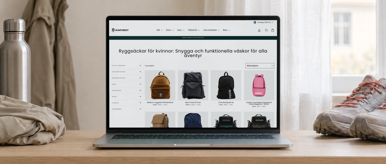 Runforest's category page for women's backpacks, with its title and a grid of backpacks, open on a laptop on an oak sideboard in a bright hallway, beside a pair of trail running shoes.