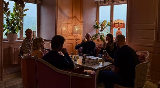 Colleagues talking on sofas in a warm-lit room at Görvälns slott