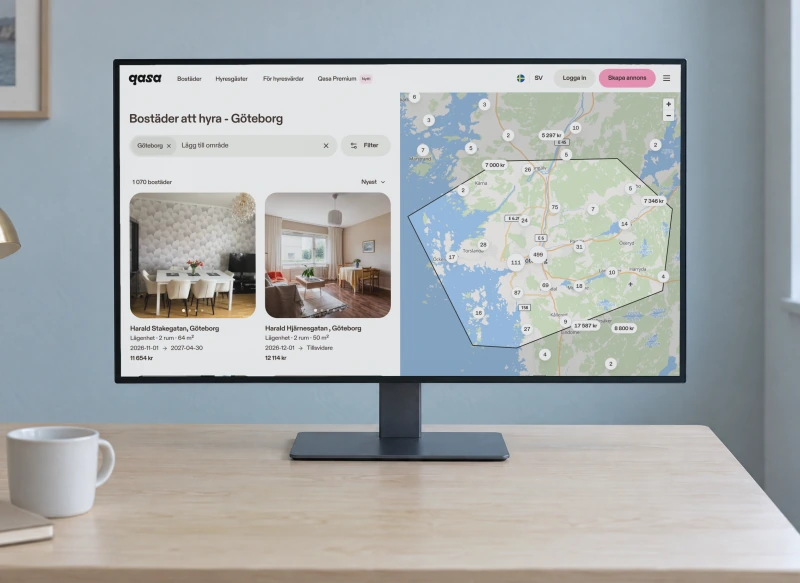 Qasa's page of homes to rent in Göteborg, with listings and a map of the city, on a monitor on a birch desk against a pale blue wall.