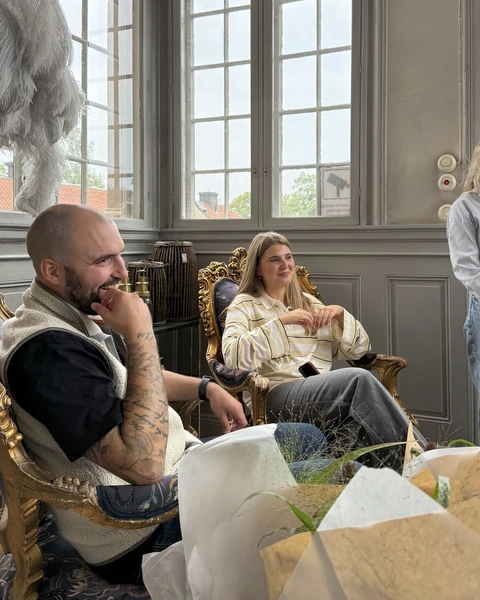 Two colleagues laughing in armchairs at Görvälns slott