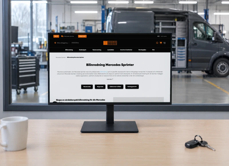 Work System's page “Bilinredning Mercedes Sprinter” on a monitor in a workshop office, with a service bay and a grey van fitted with shelving behind the glass wall.
