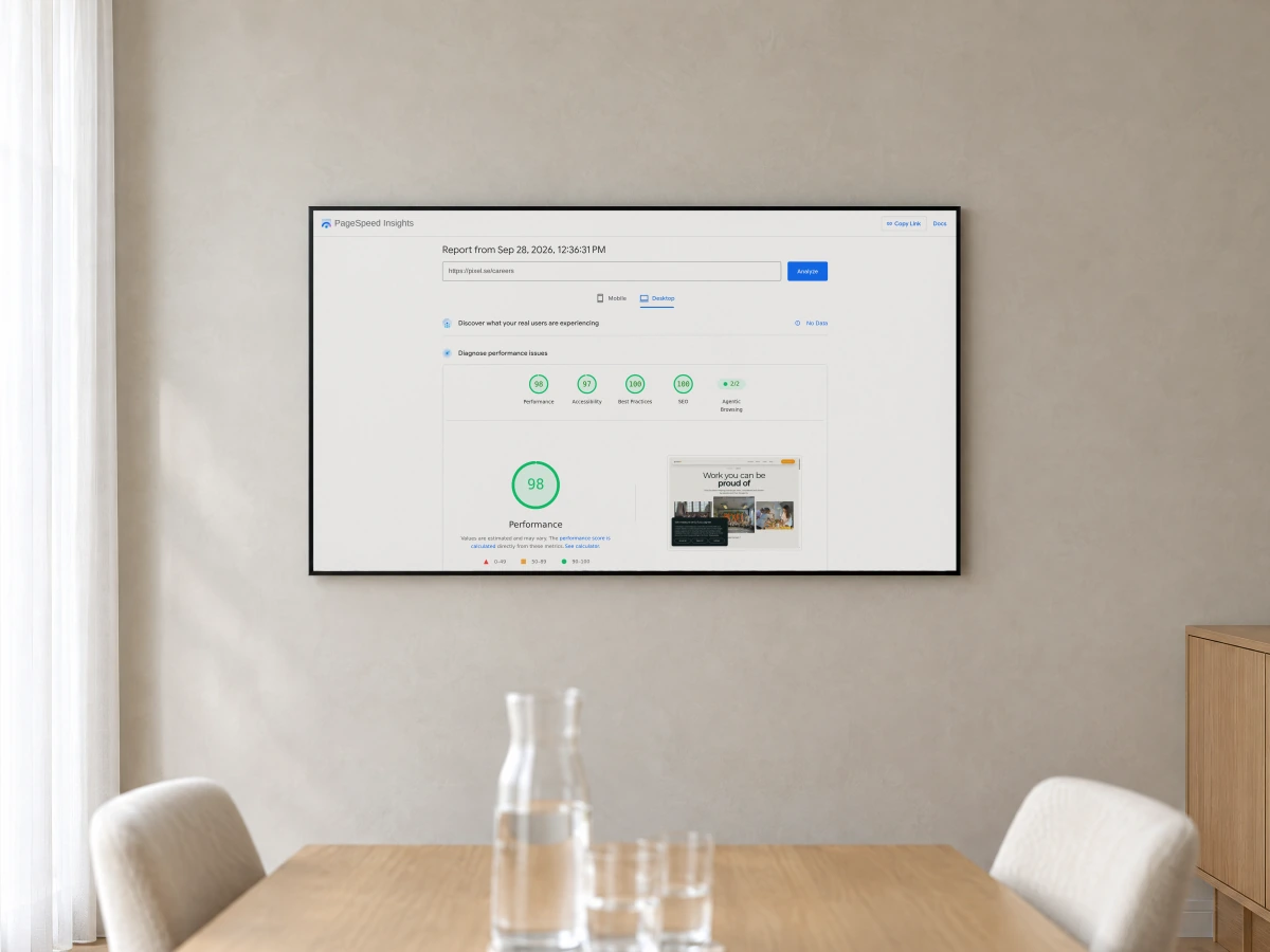 PageSpeed Insights reporting scores for a Pixel Nordic page, on a large display on the wall of a bright meeting room